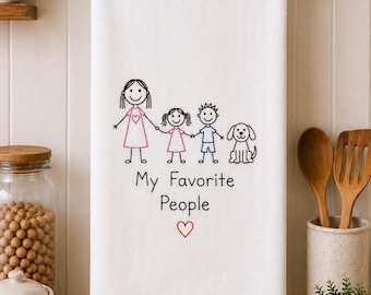 May include: A white kitchen towel featuring a black embroidered stick figure family consisting of an adult, a child, and a dog. The adult and child wear pink and blue accents. Below the figures is the black text "My Favorite People" and a red heart.