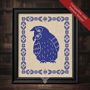 Puede incluir: Arte de punto de cruz enmarcado con un diseño de búho azul. El búho está centrado sobre un fondo beige, rodeado por un borde floral azul. El marco es negro. La pancarta roja dice "Compatible with Pattern Keeper". El texto "SARVEGA PATTERNS" está en la parte inferior.