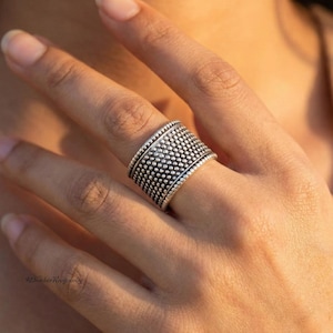 ハンドメイドの酸化スターリングシルバーのドット模様のワイドバンドリング。ボヘミアン風のテクスチャーが印象的なジュエリーギフト。