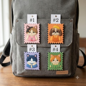 May include: Four rectangular patches shaped like postage stamps attached to a gray canvas backpack. Each patch features a cartoon animal: a calico cat labeled #1, a dog in a yellow hat labeled #2, a blue cat labeled #3, and an orange cat labeled #4.