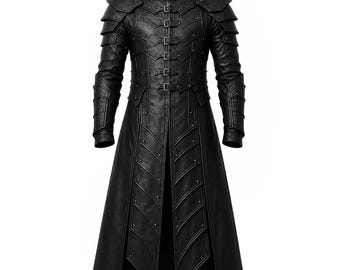 May include: A black long-length coat featuring a high collar, structured shoulder plating, and layered paneling down the front. The garment includes multiple silver-toned buckles along the center closure and decorative metal studs throughout the design.