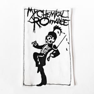 May include: A rectangular white fabric patch featuring a black screen-printed graphic of a skeleton dressed in a marching band uniform. The text "MY CHEMICAL ROMANCE" is printed in a stylised black font at the top of the patch with stitched edges.