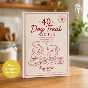 May include: A white hardback book titled 40 Dog Treat Recipes with red text and illustrations of two dogs cooking. The cover features a pumpkin, carrot, strawberry, and a bone, with the text Pupetite by Pupero and Treats Recipes Love.