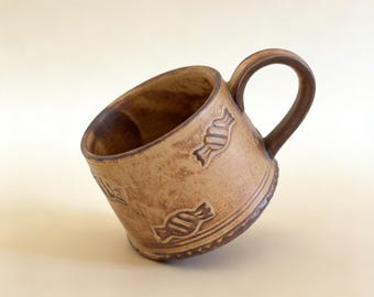 Taza rústica de cerámica marrón con diseño de caramelos en relieve, decoración de estilo granja.