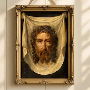 May include: An antique framed portrait of a man with a beard and a crown of thorns, draped with a white cloth. The ornate gold frame is suspended by a white ribbon tied in a bow. The artwork is against a white paneled wall.
