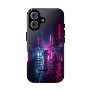May include: Black phone case featuring a neon-lit city street scene at night. The image shows a wet road reflecting the pink and blue lights of buildings and vehicles. The case has a glossy finish and a dual-camera design.