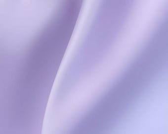 May include: A close-up of flowing, lavender-coloured fabric. The fabric has soft folds and a smooth texture, creating a sense of movement and elegance. The lighting highlights the subtle variations in colour and the gentle curves of the material.