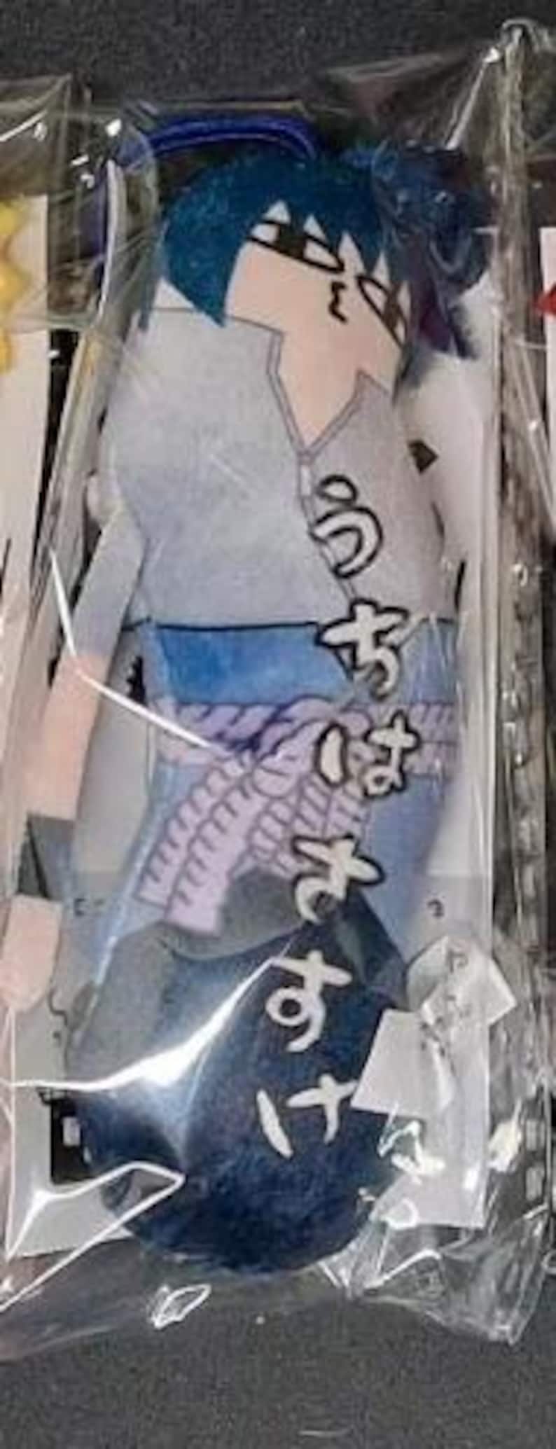 May include: A plush doll of an anime character, packaged in clear plastic. The doll features blue hair, a gray and blue outfit, and Japanese text. The doll is approximately 8 inches tall.