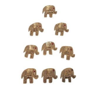 Può includere: Una collezione di abbellimenti a forma di elefante color oro. Ogni elefante ha un occhio di gemma rossa ed è decorato con paillettes e cuciture intricate. Questi abbellimenti decorativi sono ideali per progetti di artigianato.