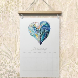 May include: A calendar featuring a watercolor painting of two blue and green birds forming a heart shape. The calendar is for January and has a grid for each day of the month.