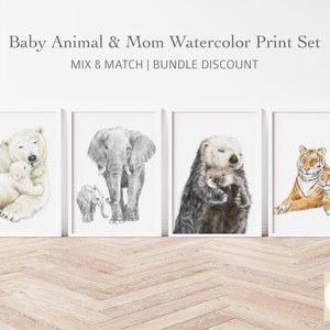 May include: Watercolor print set featuring baby animals with their mothers. Includes a polar bear and cub, an elephant and calf, an otter and pup, and two tigers. The prints are in white frames and are displayed on a white wall.