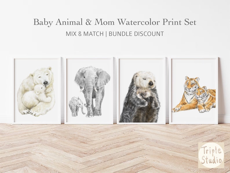 May include: Watercolor print set featuring baby animals with their mothers. Includes a polar bear and cub, an elephant and calf, an otter and pup, and two tigers. The prints are in white frames and are displayed on a white wall.