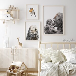 May include: Three framed animal illustrations, a robin, a sea otter, and a gorilla with a baby gorilla. The illustrations are hanging on a white wall in a nursery or child's room.
