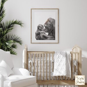 May include: A black and white illustration of a gorilla mother and baby gorilla. The mother is holding the baby in her arms and they are looking at each other. The illustration is framed and hanging on a white wall.