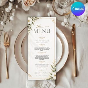 Peut inclure: Un menu de mariage avec le texte "the MENU" en écriture élégante. La carte présente un motif floral avec des fleurs blanches et des feuilles vertes. Le menu comprend des entrées, des plats, des plats principaux et des desserts. Fourchette et couteau dorés sur les côtés.