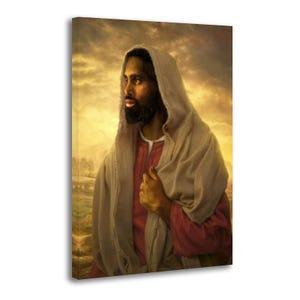 May include: A portrait of a person with dark skin, a beard, and long dark hair, wearing a hooded robe. The robe is a light beige color, and the person is wearing a red shirt underneath. The background is a golden, cloudy sky.