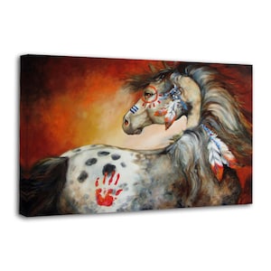 May include: A canvas print of a horse with Native American-inspired markings. The horse has a white and gray coat with a red handprint on its side. The horse's face is adorned with blue and red paint, and feathers are attached to its mane.