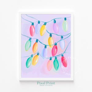 May include: A framed print featuring a string of colorful Christmas lights. The lights are painted in various colors, including red, yellow, green, and pink, against a soft purple background. The artwork is from Pixel Print Shop Studio.