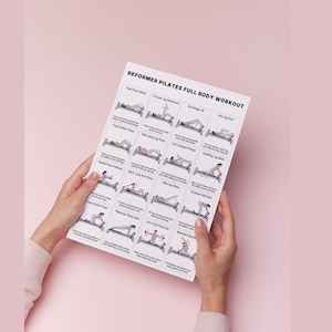 May include: A white printed sheet titled "REFORMER PILATES FULL BODY WORKOUT" held by two hands. The sheet displays illustrated exercise instructions, including "Foot Press Starter" and "Mermaid Side Bend", against a light pink background.