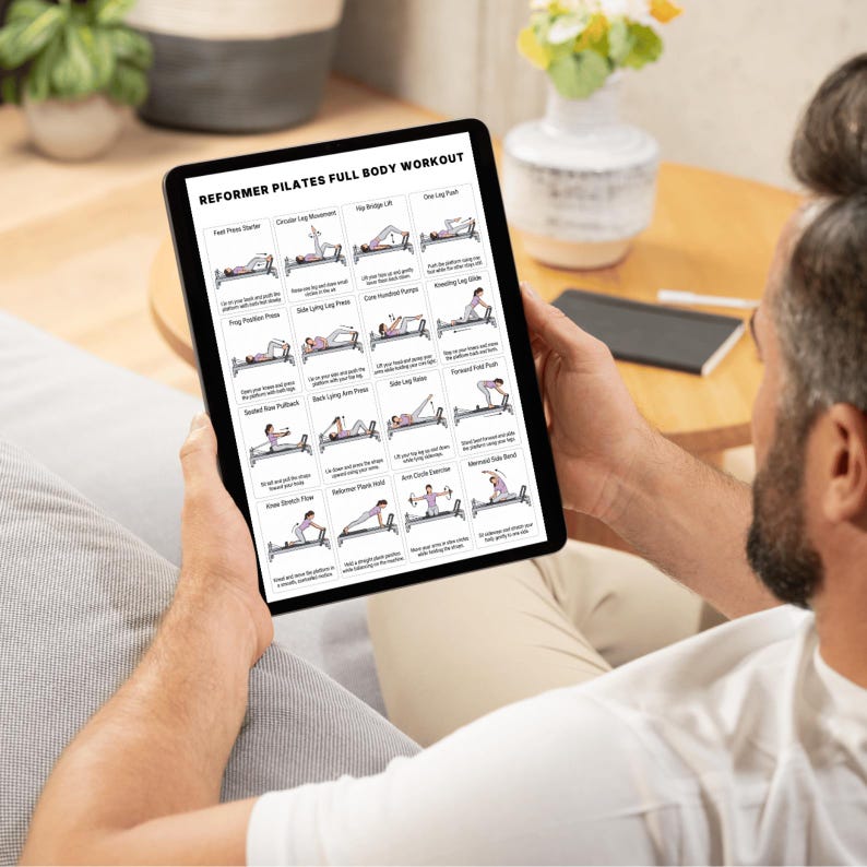 May include: A person holding a tablet displaying a "Reformer Pilates Full Body Workout" guide. The guide features illustrated exercise instructions, including "Foot Press Starter," "Circular Leg Movement," and "One Leg Push." The tablet is black, and the background includes a vase of flowers.
