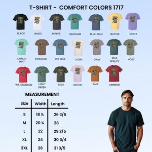 May include: A display of Comfort Colors 1717 t-shirts in various colors, including black, white, and blue jean. The shirts feature a graphic design and are available in sizes S to 2XL, with measurements provided in inches.