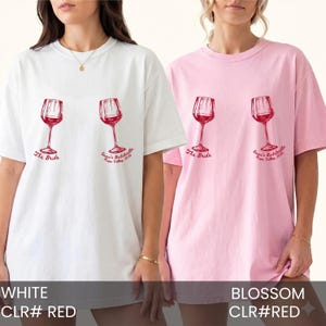 May include: A white t-shirt and a light pink t-shirt, each featuring two red wine glass illustrations. Below the left glass is the text The Bride, and below the right glass is the text Emma's Bachelorette Napa Valley 2024 in red script lettering.