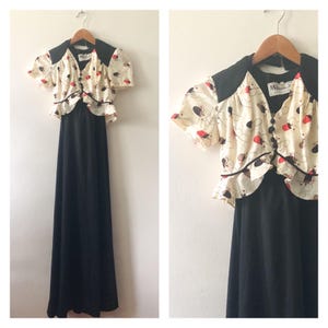 May include: A black maxi dress with a white and red patterned top. The top has a ruffled trim and a V-neckline. The dress is labelled "Miss Candy."