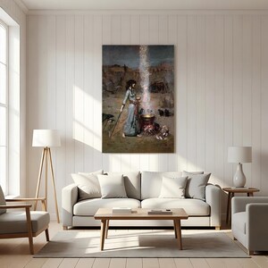 May include: A framed print of a painting depicting a woman in a long blue dress standing near a cauldron with a bright light emanating from it. The artwork has a vintage aesthetic, with a desert landscape in the background.
