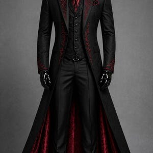 Könnte beinhalten: Ein schwarzer langer Mantel mit roter Blumenstickerei an Revers und Manschetten, kombiniert mit einer schwarzen Weste, einem schwarzen Hemd, einer gemusterten roten Krawatte und einer schwarzen Hose. Der Mantel hat ein dunkelrotes Futter.