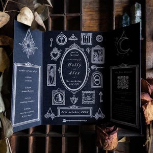 May include: A black tri-fold wedding invitation card featuring white line art illustrations of celestial motifs, frames, and botanical elements. The text reads: you're invited to the wedding of Holly and Alex at the workshop and loft, 31st October 2026.