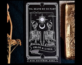 Op de afbeelding: Zwart-wit digitale download met skeletillustraties, hemelse elementen en de tekst "TIL DEATH DO US PART". De namen "CHLOE & LYDIA" staan op een banner, met de datum "8TH OCTOBER 2022" eronder. De woorden "DOWNLOAD & EDIT TODAY" en "DIGITAL DOWNLOAD" zijn ook aanwezig.