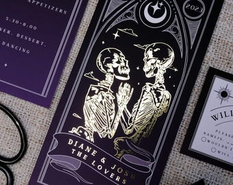 May include: A set of gothic-themed wedding invitations. The main card features gold foil skeletons embracing under a crescent moon and stars, with the text "DIANE & JOSH THE LOVERS". Additional cards include event details and RSVP information.