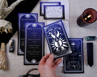 May include: Dark blue and white wedding invitation suite with celestial and art deco design elements. Includes invitation cards, RSVP cards, and order of the day cards. A hand holds a "Save the Date" card with the names "Emma & Sam" and the date "15th March 2024".