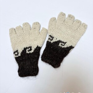 May include: A pair of fingerless gloves featuring a two-tone design with a cream-colored upper section and a dark brown lower section. A wave-like pattern separates the two colors. The text Kosha Argentina is printed in the bottom right corner.