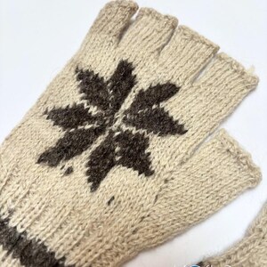 May include: A pair of fingerless gloves in a light beige knit featuring a dark brown star-shaped pattern on the back of the hand and a dark brown horizontal band at the wrist. The text Kosha Argentina is printed in the bottom right corner.