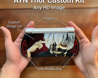 May include: AYN Thor Custom Kit with a custom image lid featuring an anime character, red triggers, and black low-profile grips. The text reads AYN Thor Custom Kit, Any HD Image, Triggers, Custom Image Lid, Low-Profile Grip, and Free Triggers.