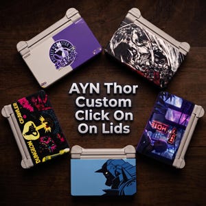 May include: Five AYN Thor handheld gaming consoles with custom lid designs arranged in a circle. The lids feature various graphic prints including a purple Mewtwo design, a dark fantasy illustration, a dungeon crawler theme, a neon city scene, and a blue robot silhouette. The text "AYN Thor Custom Click On On Lids" is centred in the middle.