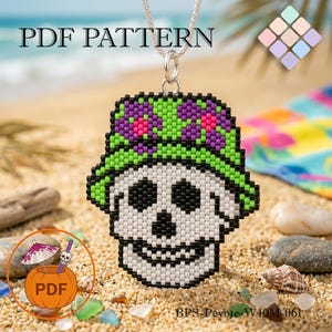 Puede incluir: Un colgante de calavera con cuentas con un sombrero verde y morado, ojos negros y una cara blanca, colgado de una cadena de plata. El colgante está en una playa de arena con las palabras "PDF PATTERN" en la parte superior. Una calabaza con un cóctel está en la esquina inferior izquierda.