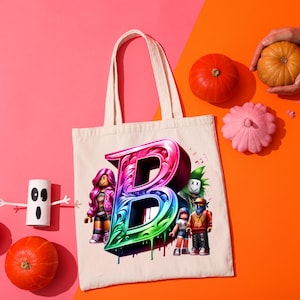 Puede incluir: Un bolso tote color crema con una gran letra "B" goteando y colorida, con personajes de dibujos animados. La imagen incluye calabazas y un fantasma de papel sobre un fondo rosa y naranja.