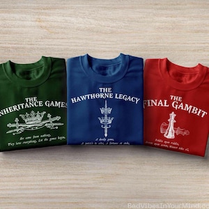 Può includere: Tre magliette in verde scuro, blu navy e rosso. La maglietta verde presenta una corona, spade e il testo The Inheritance Games. Quella blu mostra una corona, una spada e The Hawthorne Legacy. Quella rossa mostra un pezzo degli scacchi e The Final Gambit.
