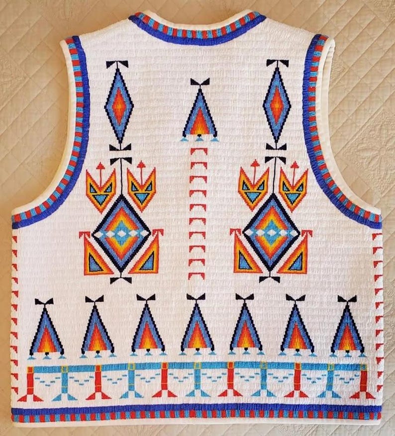 May include: White beaded vest with colorful geometric patterns. The design includes diamonds, triangles, and other shapes in shades of blue, orange, and red. The vest has a blue and red beaded trim.