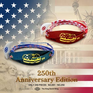 Puede incluir: Dos hondas, una roja y otra azul, con cordones trenzados y lengüetas de liberación blancas. La honda roja tiene el texto 250th en dorado y la azul en amarillo. El texto 250th Anniversary Edition y The King David Sling es visible.