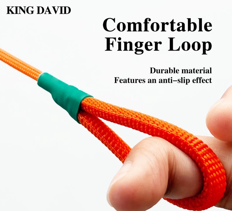 Puede incluir: Un cord&oacute;n tejido de color naranja con un conector de tubo termorretr&aacute;ctil verde y un lazo para el dedo. El texto KING DAVID, Comfortable Finger Loop y Durable material Features an anti-slip effect est&aacute; impreso sobre el fondo blanco.