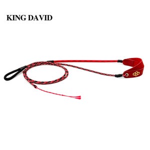 Puede incluir: Una honda de la marca King David con un cord&oacute;n trenzado en rojo y negro, un lazo negro en un extremo y una bolsa de cuero roja en el otro. La bolsa de cuero roja tiene un emblema dorado y est&aacute; sujeta al cord&oacute;n mediante un ojal met&aacute;lico.