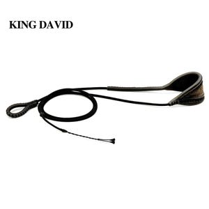 Puede incluir: Una honda negra con el texto KING DAVID impreso encima. La honda presenta un cordón largo y fino, un lazo trenzado en un extremo y una sección curva, acolchada y más ancha en el otro extremo, construida con costuras visibles en los bordes.