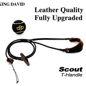 May include: A black tennis ball with a yellow logo and white lines, accompanied by a black cord with a brown wooden T-handle and a brown leather strap. Text reads: KING DAVID, Leather Quality Fully Upgraded, and Scout T-Handle.
