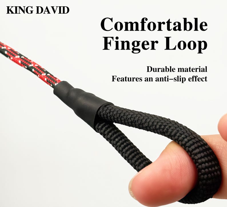 Puede incluir: Un lazo de cuerda negra para el dedo unido a una correa de cuerda con patr&oacute;n rojo y negro mediante un conector negro. El texto KING DAVID, Comfortable Finger Loop y Durable material Features an anti-slip effect aparece sobre el fondo blanco.
