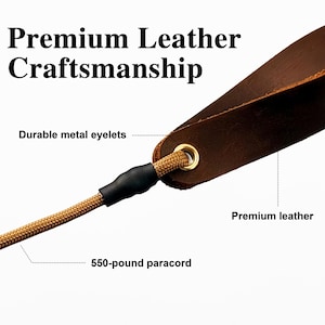 May include: A brown leather strap with a gold-colored metal eyelet and a tan 550-pound paracord attached by a black sleeve. The text Premium Leather Craftsmanship, Durable metal eyelets, Premium leather, and 550-pound paracord are visible.