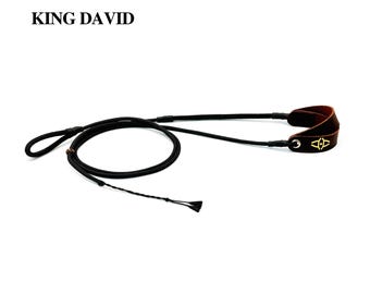 May include: A black rope leash with a brown leather handle featuring a gold logo and the text KING DAVID. The leash includes a metal ring, a sliding bead, and a braided end. The design incorporates a loop for a handle and a long cord section.