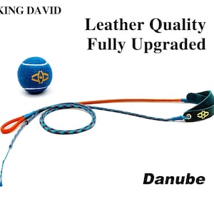 Puede incluir: Una pelota de tenis azul con un logotipo amarillo, una correa de cuerda trenzada larga de color naranja y azul, y un asa de cuero verde oscuro con un logotipo amarillo. El texto dice: KING DAVID, Leather Quality Fully Upgraded y Danube.